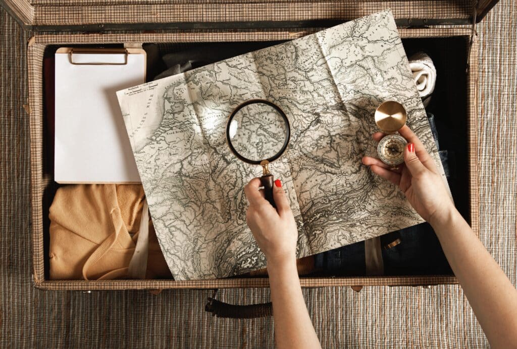 Mano de una persona sosteniendo una brújula antigua sobre un mapa, simbolizando la búsqueda del propósito para construir una marca personal auténtica.